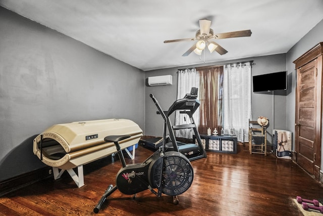 workout area with wood-type flooring, a ceiling fan, a wall unit AC, and baseboards