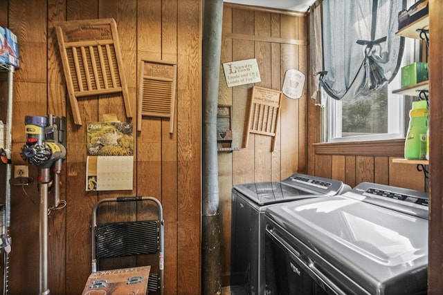 washroom featuring wooden walls, independent washer and dryer, and laundry area