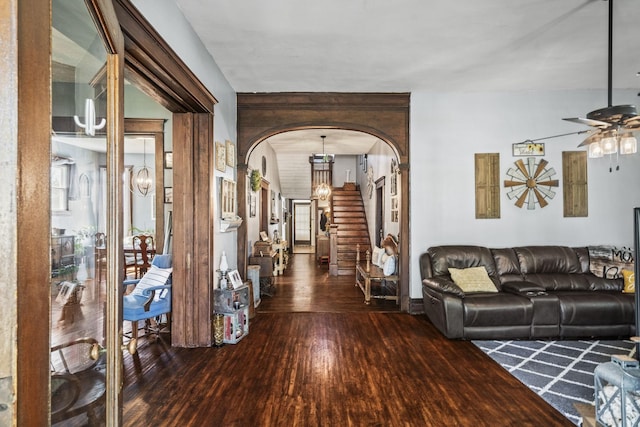 living area featuring stairway, hardwood / wood-style flooring, ceiling fan, and arched walkways