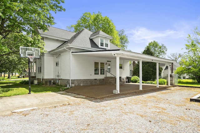 view of front of property featuring a shingled roof, entry steps, a carport, a front yard, and concrete driveway