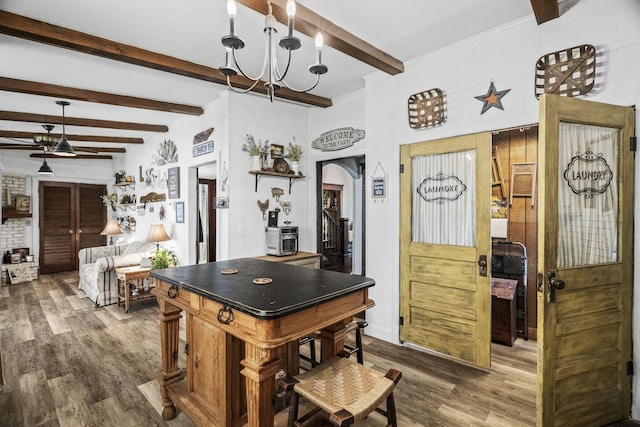 kitchen with arched walkways, a chandelier, beam ceiling, and wood finished floors