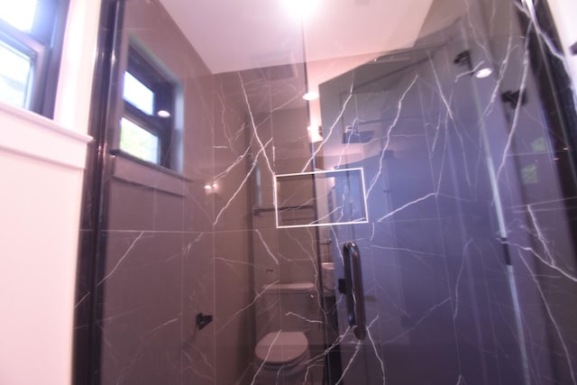 full bathroom with a marble finish shower