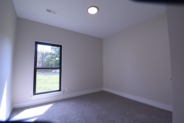 carpeted spare room featuring baseboards and visible vents