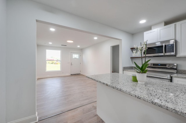 117 Apollo Ct W, Antioch, TN 37013 - kitchen with white cabinets, light stone countertops, light wood-style flooring, stainless steel appliances, and recessed lighting