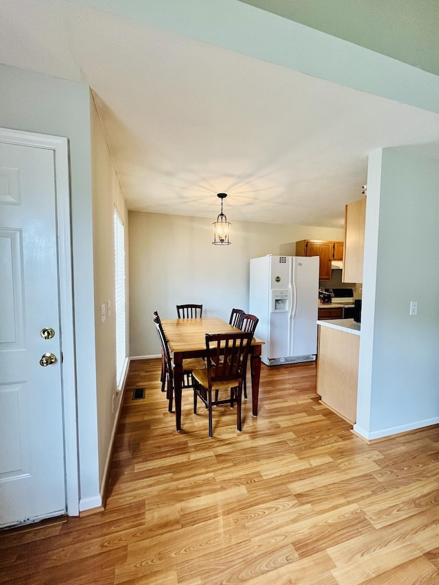dining room featuring light wood-type flooring and baseboards