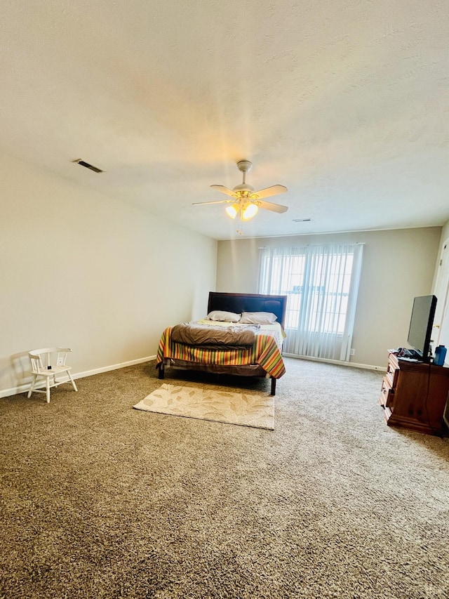 carpeted bedroom with visible vents, a ceiling fan, and baseboards