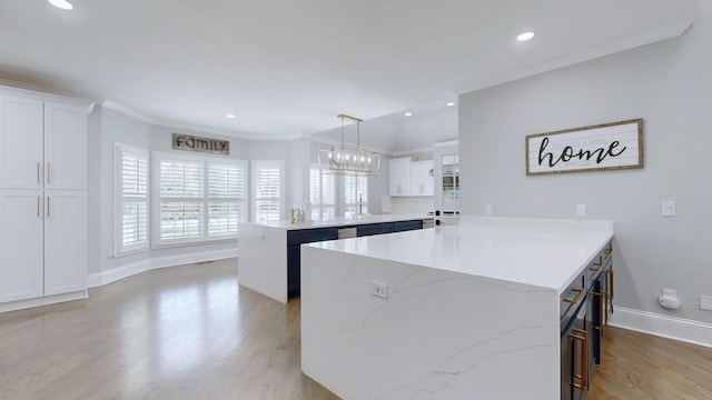 kitchen with light wood-style flooring, white cabinetry, a breakfast bar area, baseboards, and a peninsula