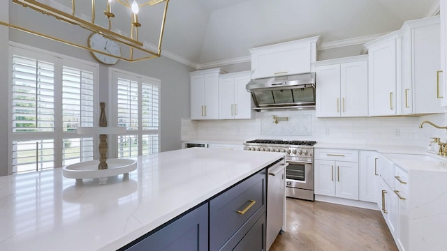 kitchen with stainless steel range, white cabinetry, under cabinet range hood, and tasteful backsplash