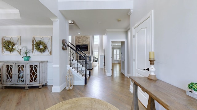 entrance foyer with stairway, wood finished floors, crown molding, and baseboards