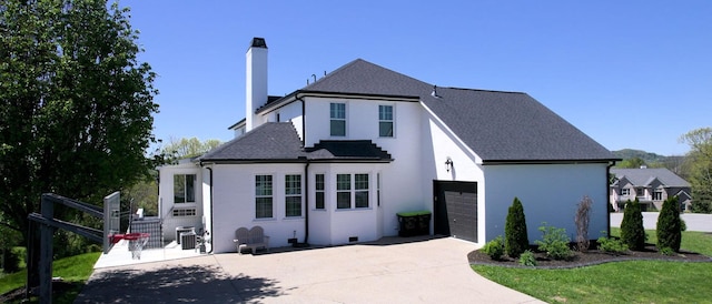 view of front of property featuring driveway, a chimney, roof with shingles, fence, and brick siding