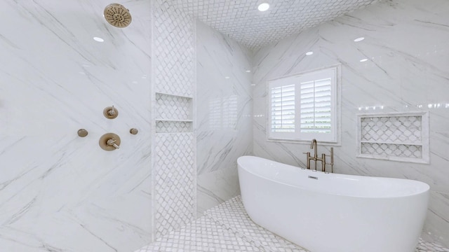 bathroom with a tile shower, a soaking tub, and tile walls