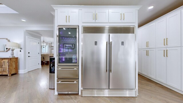 kitchen with recessed lighting, stainless steel built in fridge, white cabinets, and light wood-style flooring