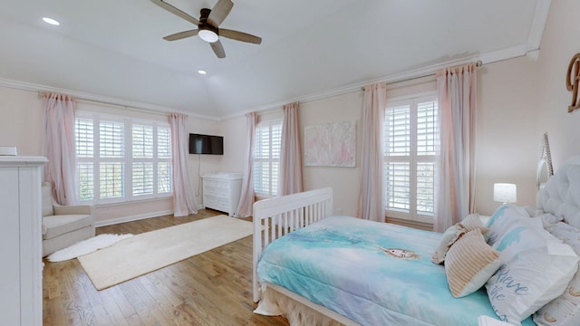 bedroom with wood finished floors, a ceiling fan, and crown molding