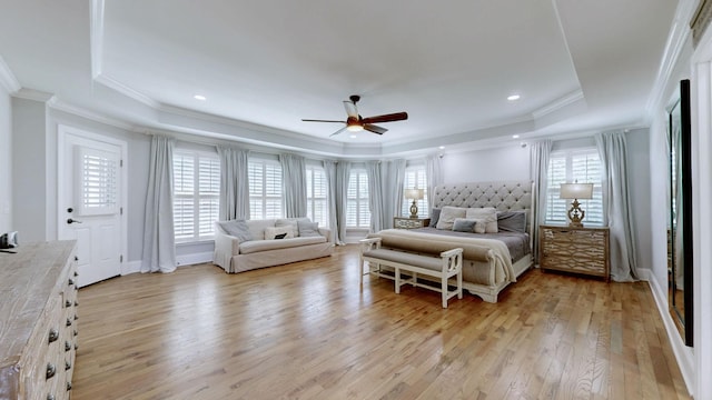 bedroom featuring crown molding, ceiling fan, a tray ceiling, baseboards, and light wood finished floors