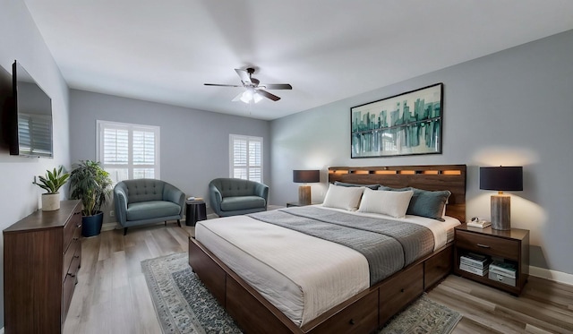 bedroom with baseboards, light wood-type flooring, and a ceiling fan