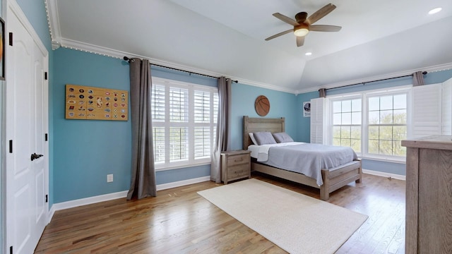 bedroom featuring lofted ceiling, ceiling fan, baseboards, ornamental molding, and wood finished floors