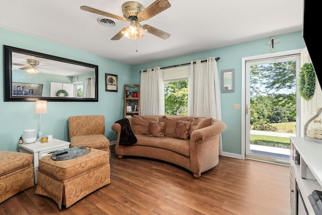 living room featuring wood finished floors, ceiling fan, and plenty of natural light