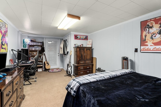 carpeted bedroom with a decorative wall and crown molding