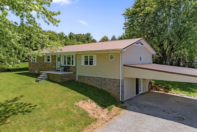 ranch-style house featuring a front yard, metal roof, driveway, a carport, and stone siding