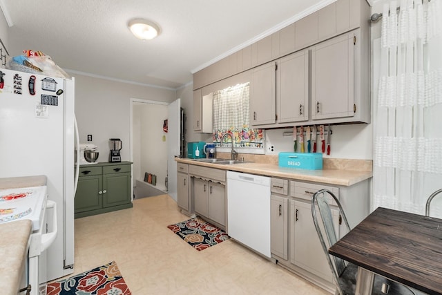 kitchen with light floors, white appliances, light countertops, ornamental molding, and a sink