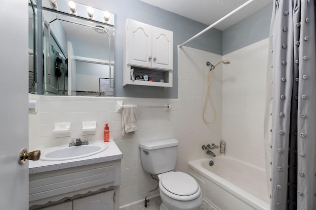 bathroom featuring tile walls, vanity, shower / bath combination with curtain, toilet, and a textured ceiling