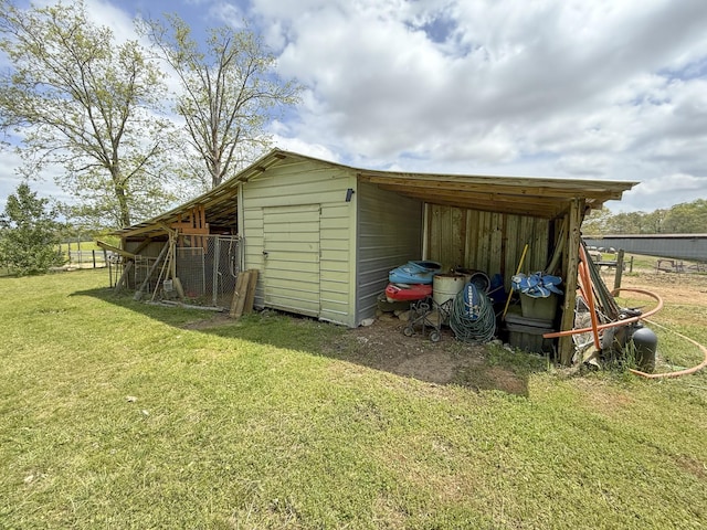 view of outbuilding with fence and an outbuilding