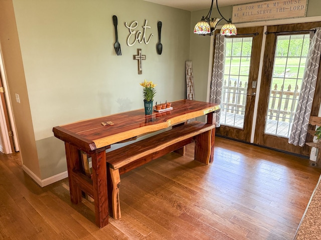 dining area with baseboards and wood-type flooring