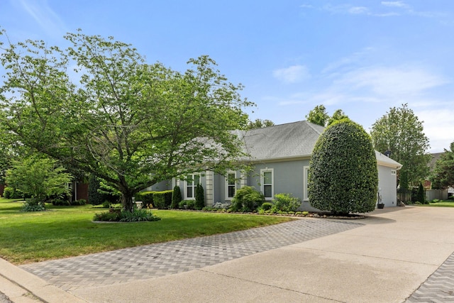 view of property exterior featuring a yard, driveway, and stucco siding