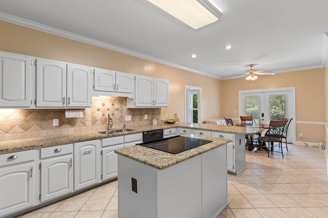 kitchen featuring backsplash, a center island, a sink, black appliances, and a peninsula