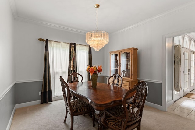dining room with crown molding, baseboards, a chandelier, and light carpet