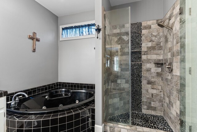 bathroom featuring a tub with jets and a shower stall