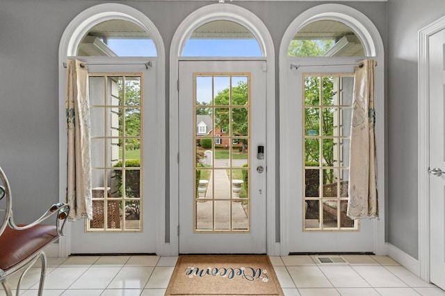 doorway to outside featuring a wealth of natural light, light tile patterned flooring, and visible vents