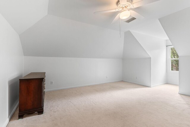 additional living space featuring ceiling fan, visible vents, carpet floors, baseboards, and lofted ceiling
