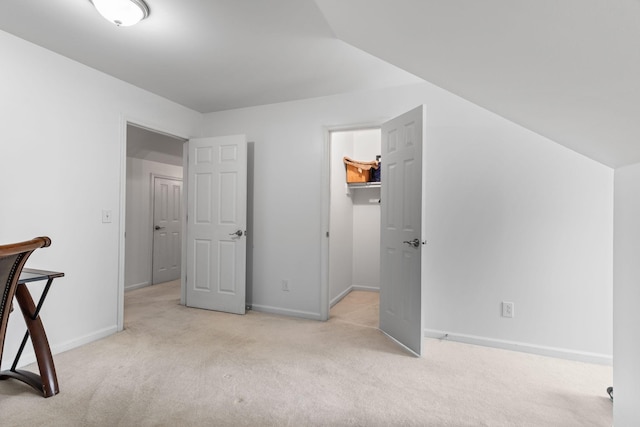 interior space with baseboards, a walk in closet, and carpet