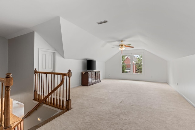 bonus room with a ceiling fan, visible vents, baseboards, lofted ceiling, and light carpet