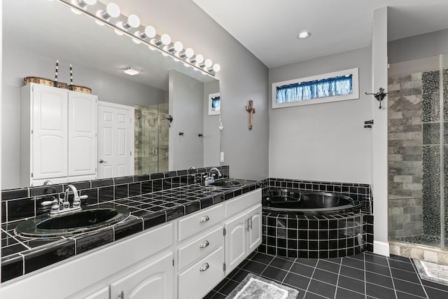 bathroom featuring a sink, tile patterned flooring, a stall shower, and a garden tub