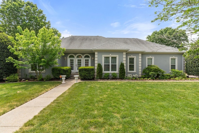 view of front of home featuring a front lawn, roof with shingles, stucco siding, and french doors