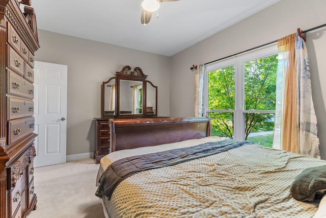 bedroom with a ceiling fan, baseboards, and light carpet
