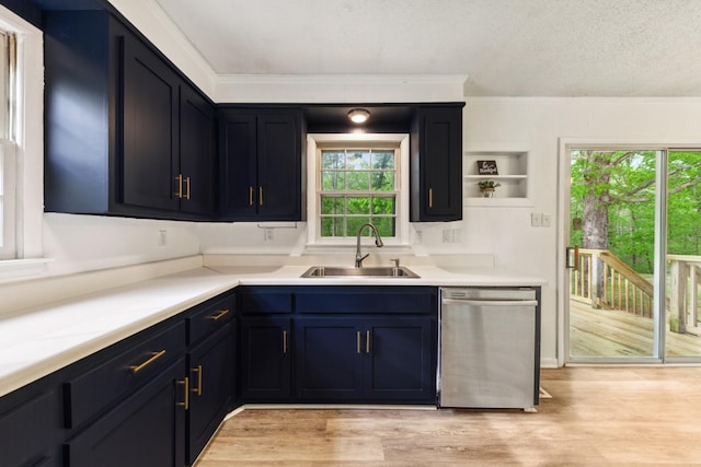 kitchen with blue cabinetry, stainless steel dishwasher, light wood-type flooring, a sink, and light countertops