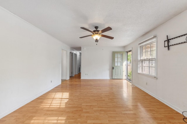 spare room featuring a textured ceiling, ceiling fan, baseboards, and light wood finished floors