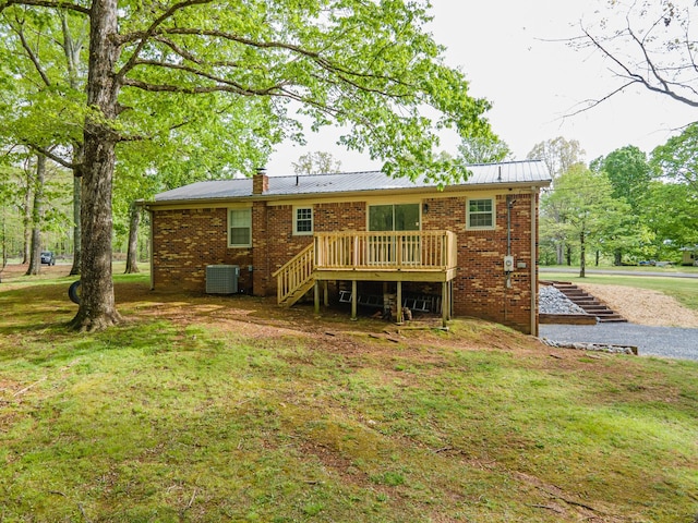 back of house with stairs, brick siding, a deck, a chimney, and metal roof
