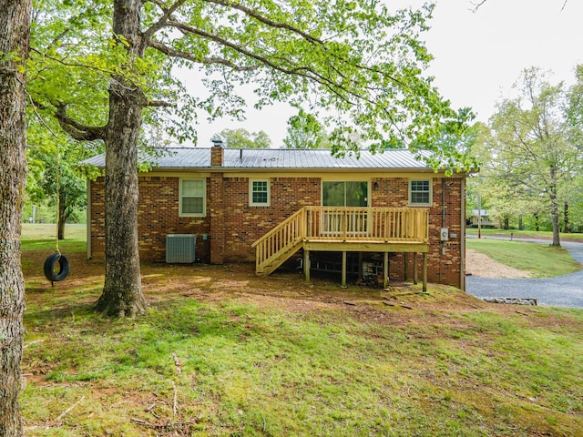 back of property with brick siding, stairway, a deck, central AC unit, and a chimney