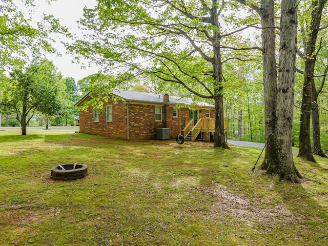 view of yard featuring a fire pit and central AC