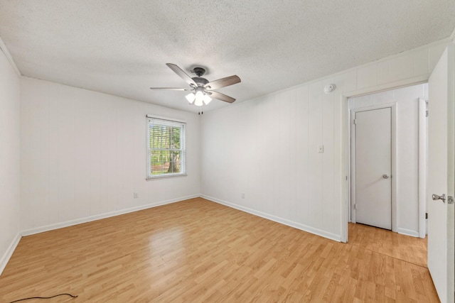 unfurnished room featuring baseboards, ceiling fan, light wood-type flooring, and a textured ceiling