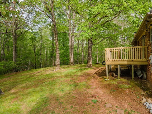 view of yard featuring a view of trees and a wooden deck