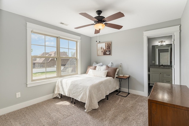 bedroom with visible vents, light carpet, baseboards, ceiling fan, and a sink