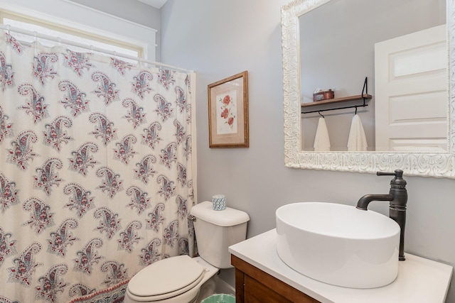 bathroom featuring vanity, toilet, and curtained shower