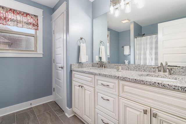 bathroom featuring double vanity, baseboards, a sink, and marble finish floor