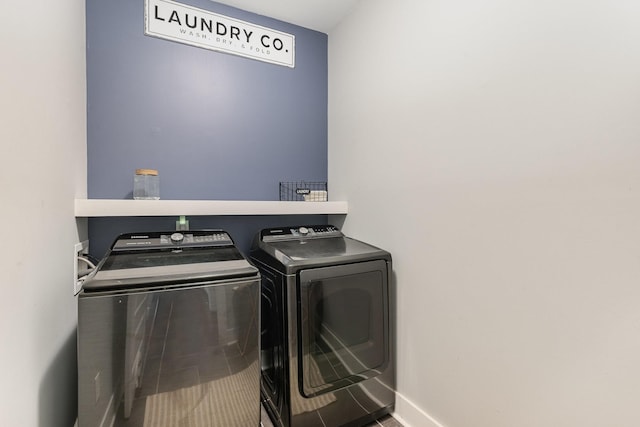 clothes washing area featuring baseboards, laundry area, and washer and dryer