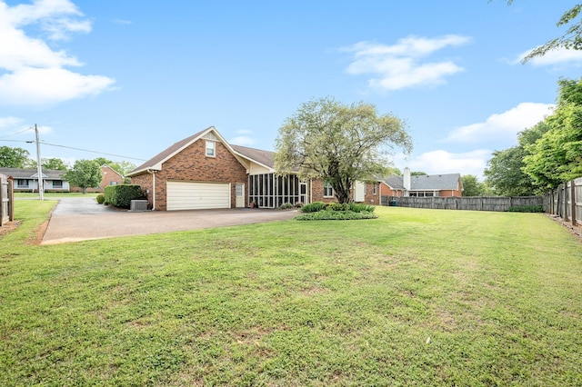view of yard with fence, driveway, and a garage